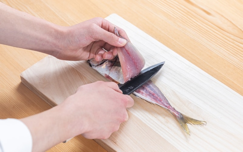 写真：イカ割き包丁で魚を捌いている様子